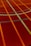 A sports court with intersecting lines in orange and blue, creating geometric patterns on a reddish-brown surface.