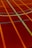 A sports court with intersecting lines in orange and blue, creating geometric patterns on a reddish-brown surface.