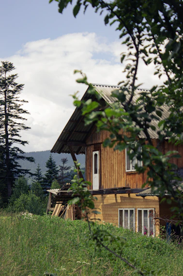 A handcrafted wooden house nestled in a lush green landscape near Graz.