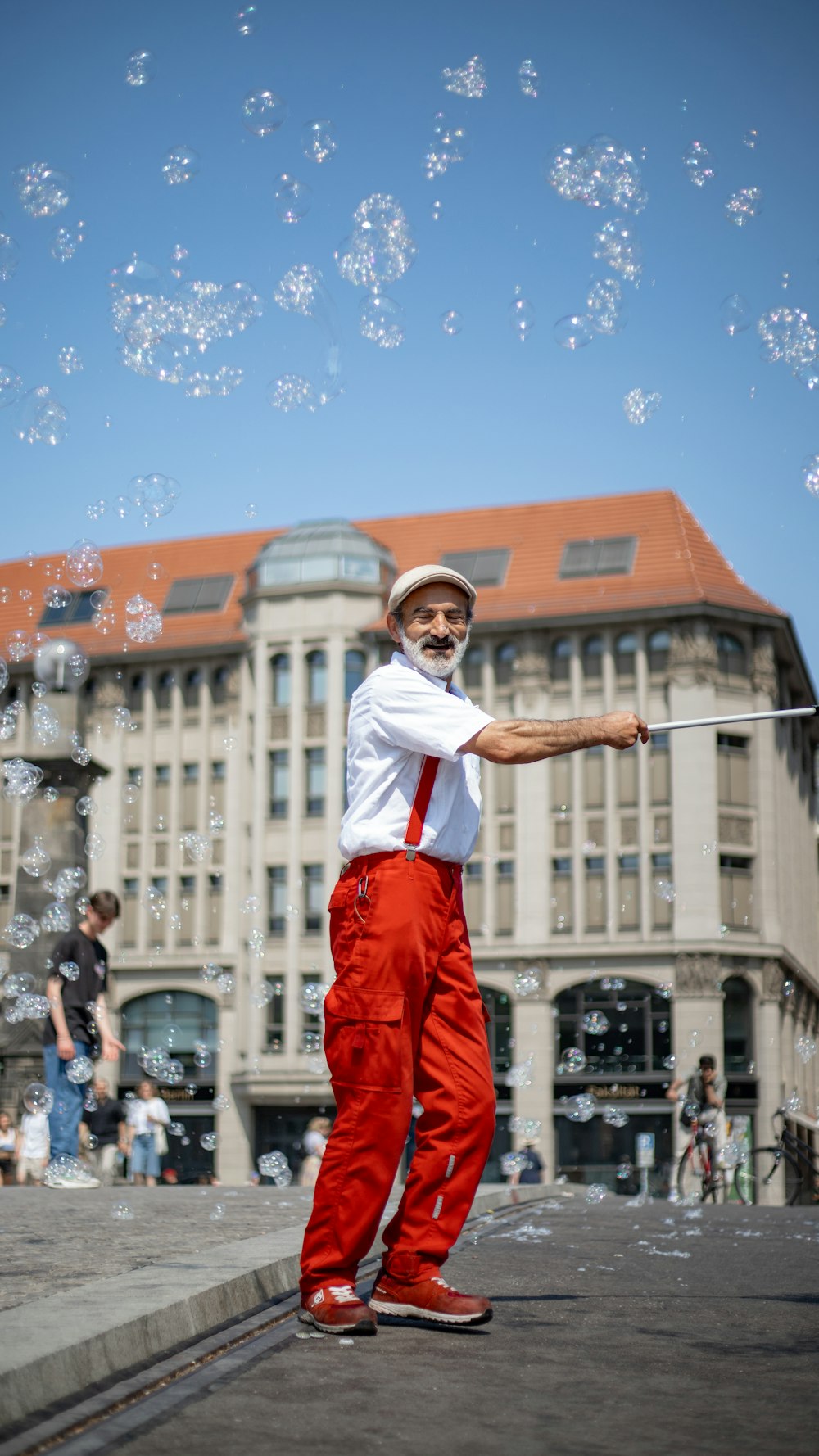 a man in red pants and a white shirt is playing with bubbles
