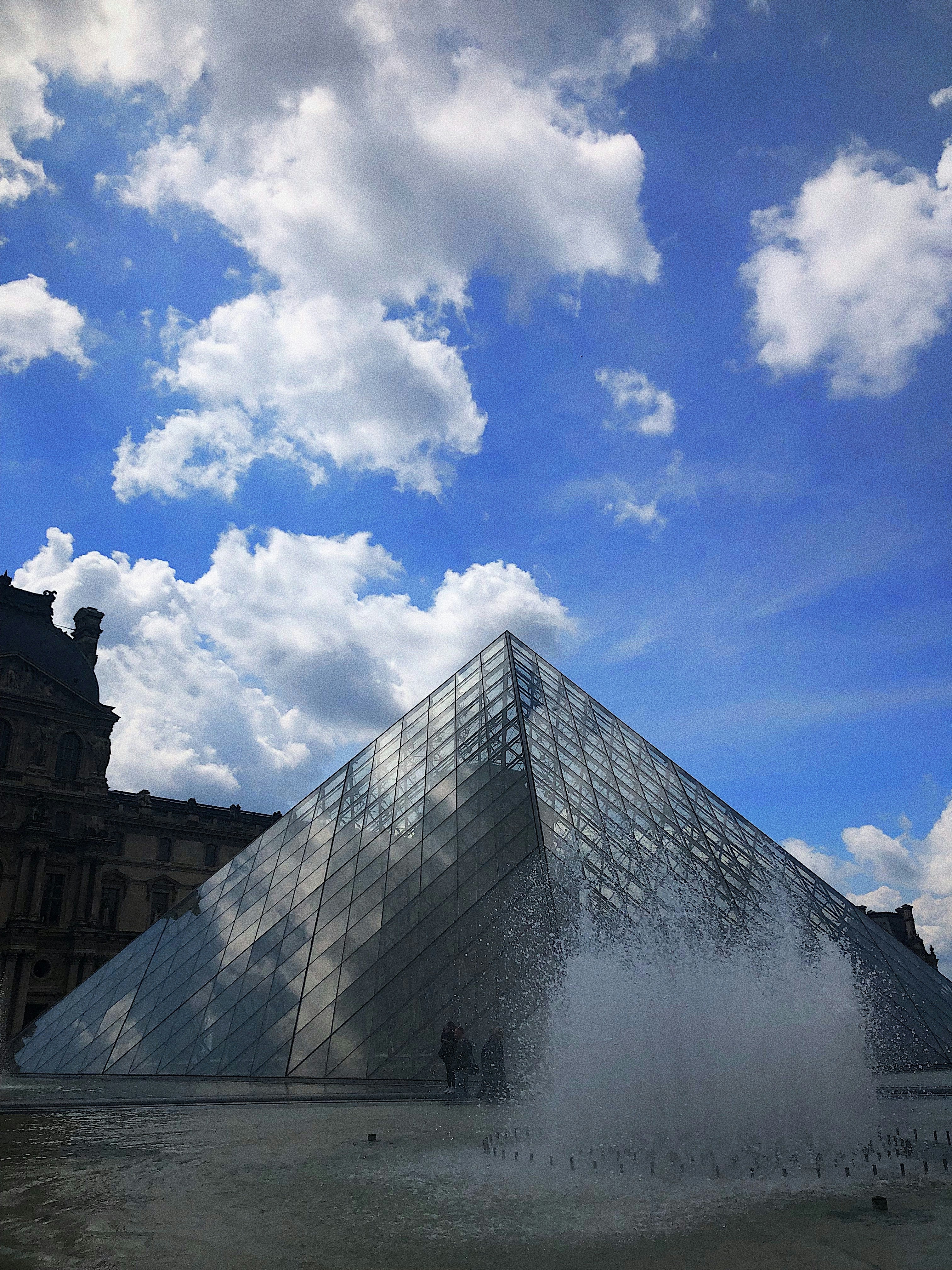 A large glass pyramid in front of a building photo – Free City Image on ...