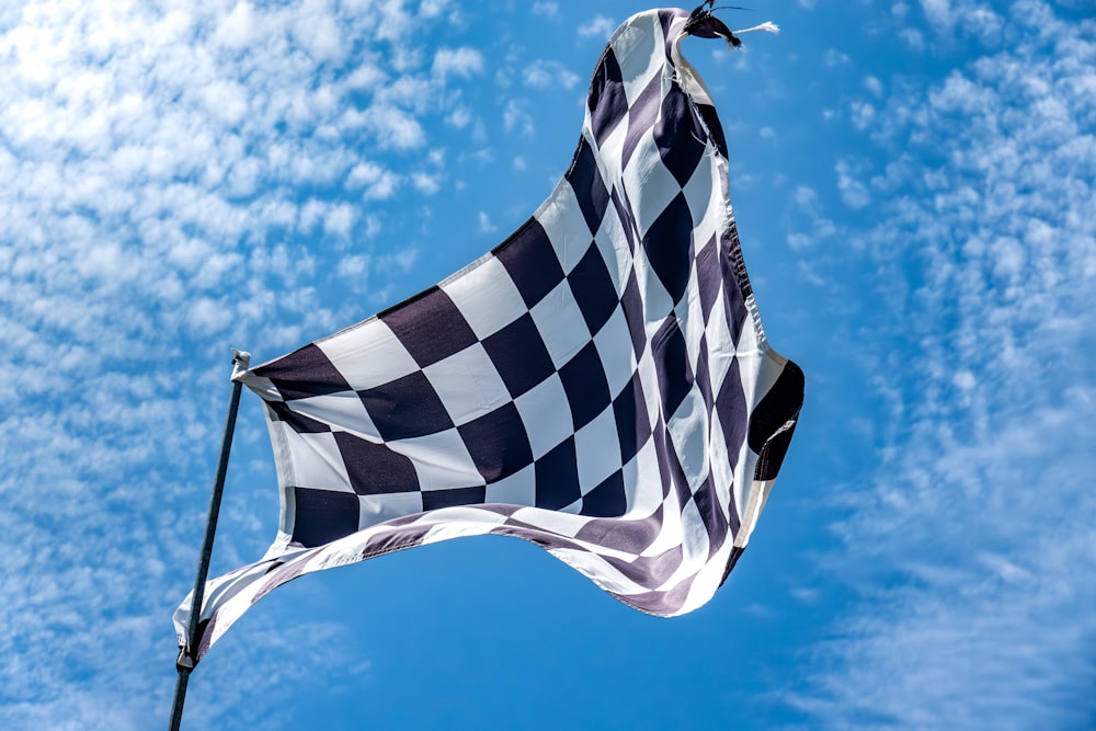 a black and white checkered flag flying in the sky