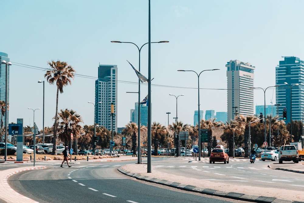 a city street with palm trees and tall buildings