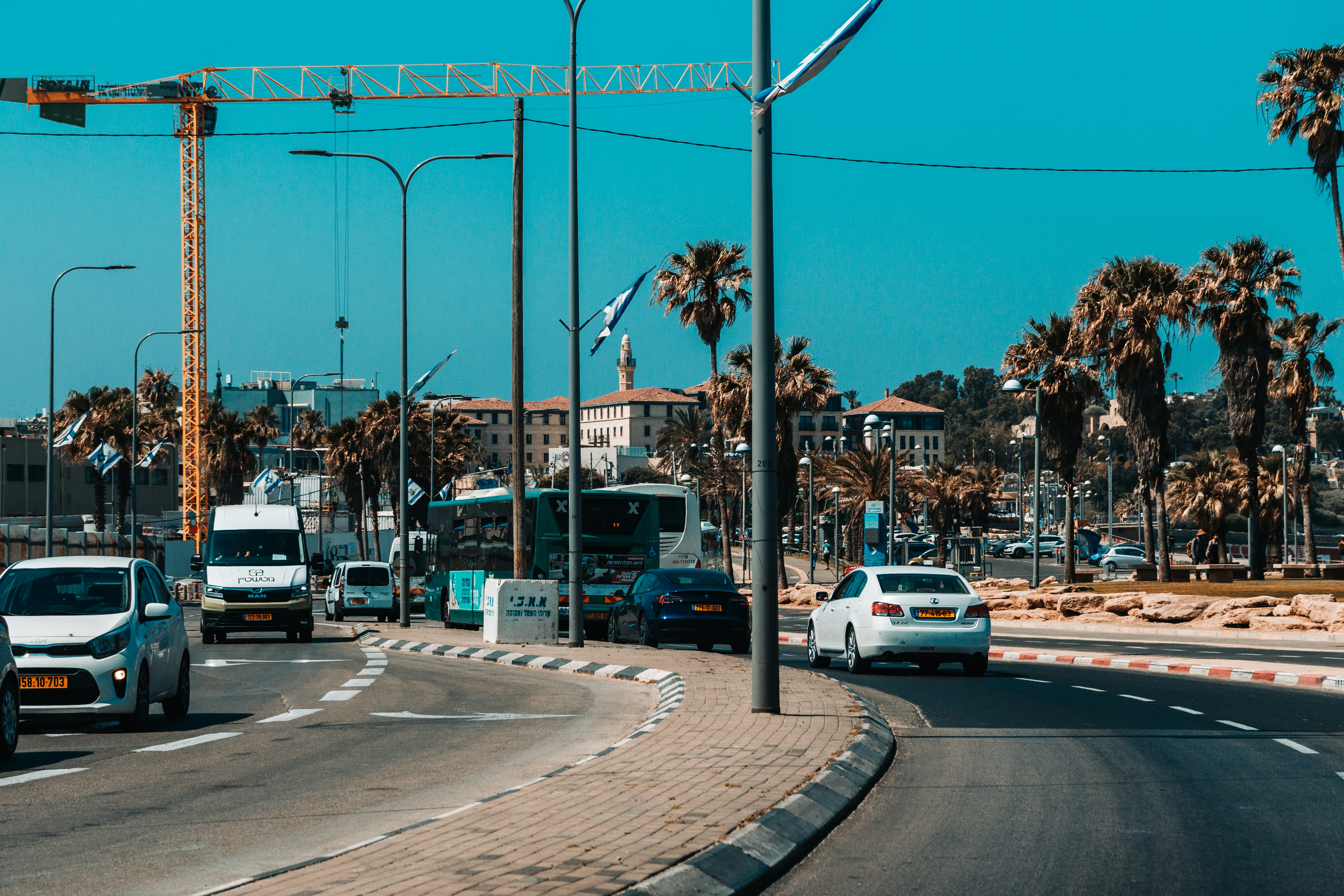 a busy city street with palm trees on both sides