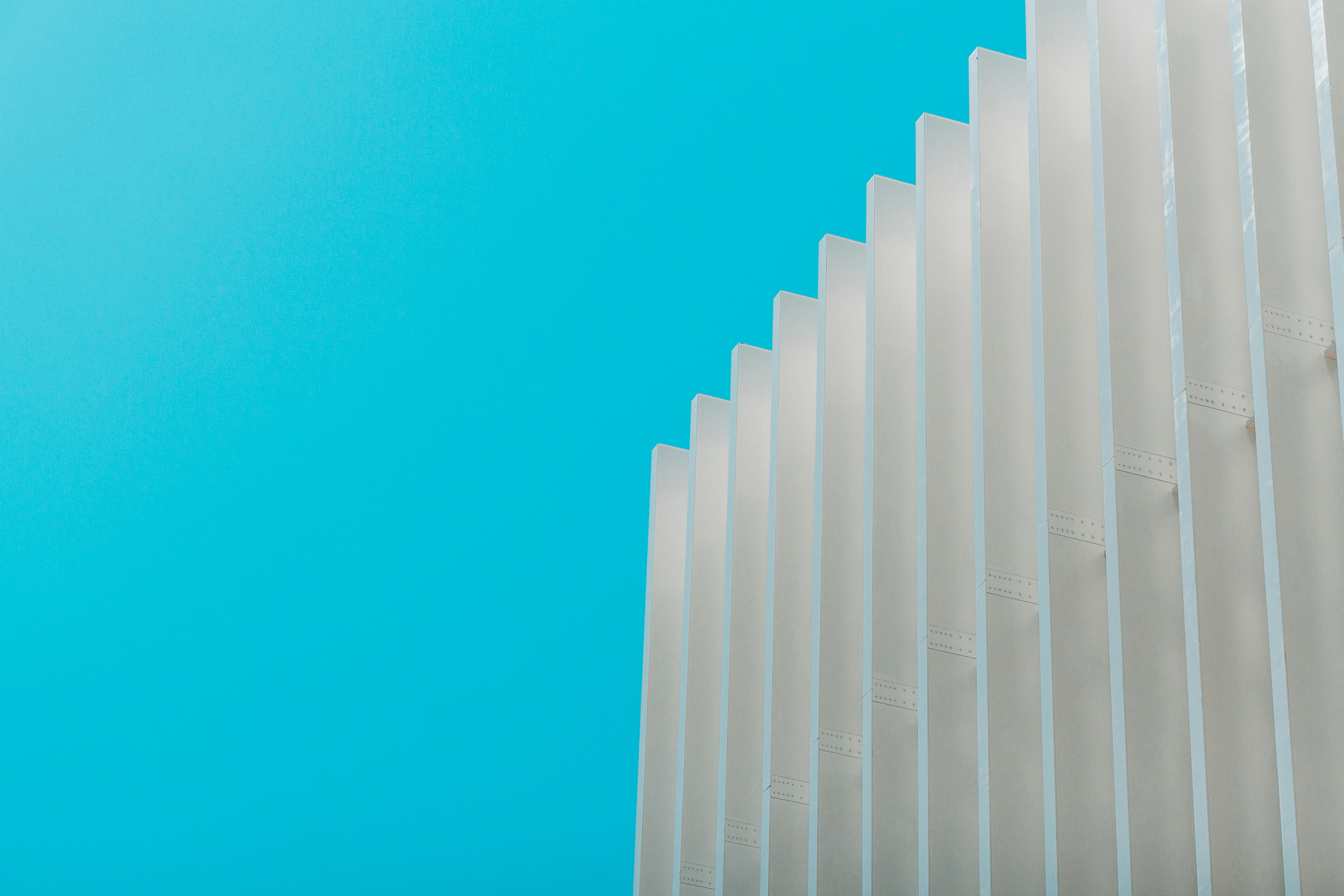 a tall white building with a blue sky in the background
