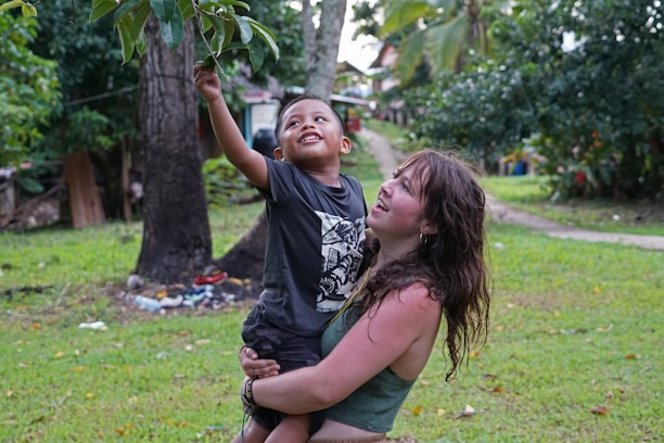 A young boy engaged in a playful physical therapy session with a caring therapist.