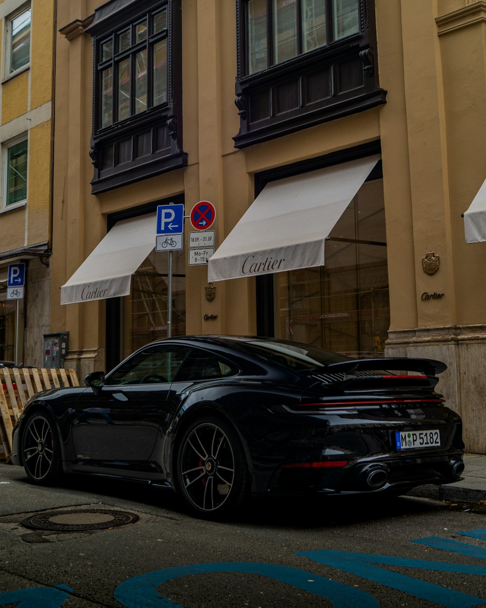 a black sports car parked in front of a building