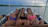 Friends laughing together aboard a boat, with water splashing around them.