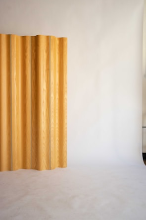 A sleek wooden slatted panel mounted on a contemporary wall.