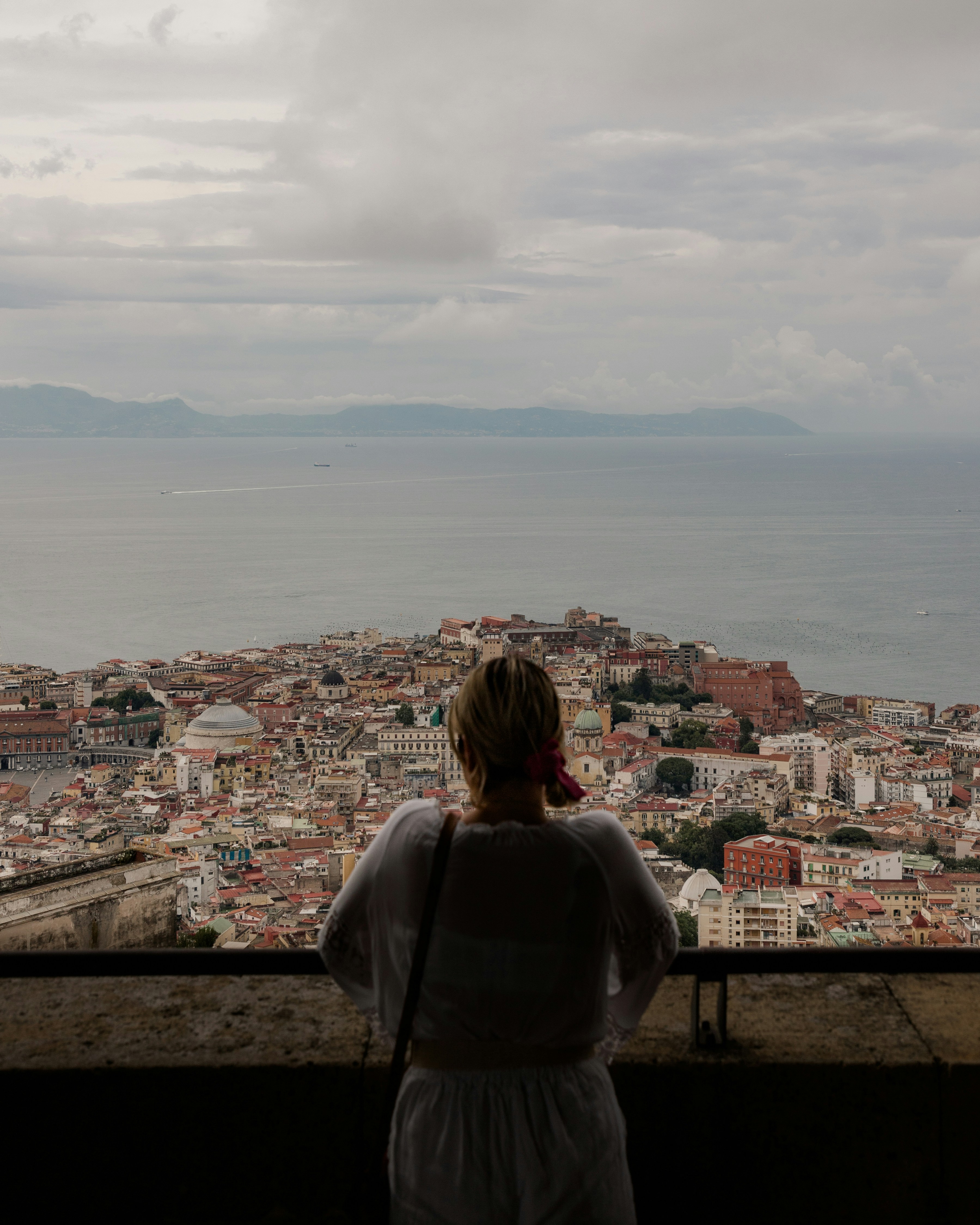 Una mujer mirando hacia una ciudad desde una torre