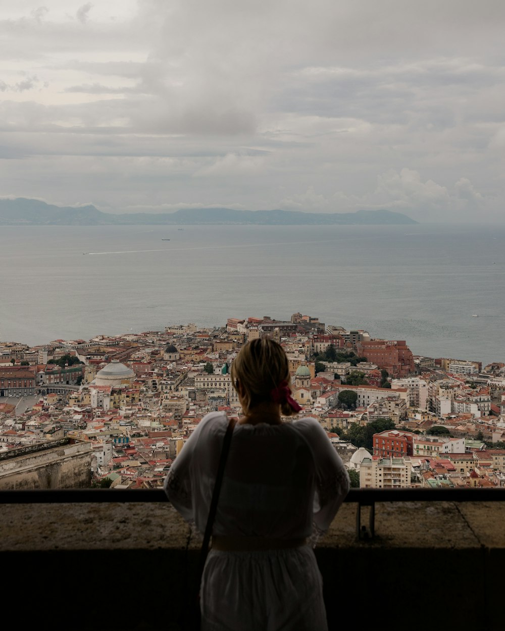 a woman looking out over a city from a tower