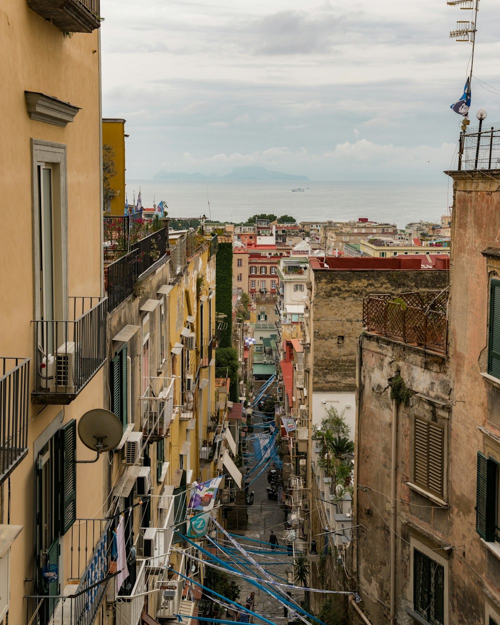 a narrow city street lined with buildings and balconies