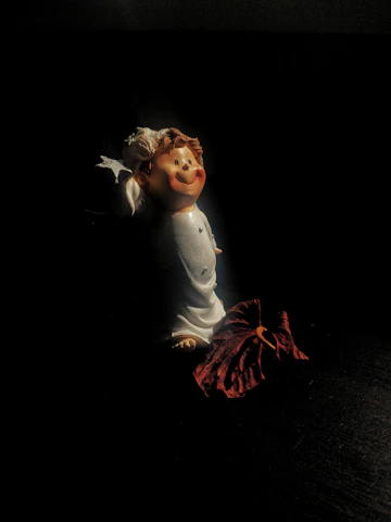 Close-up of a delicate resin figure with romantic and fantasy elements bathed in soft warm light