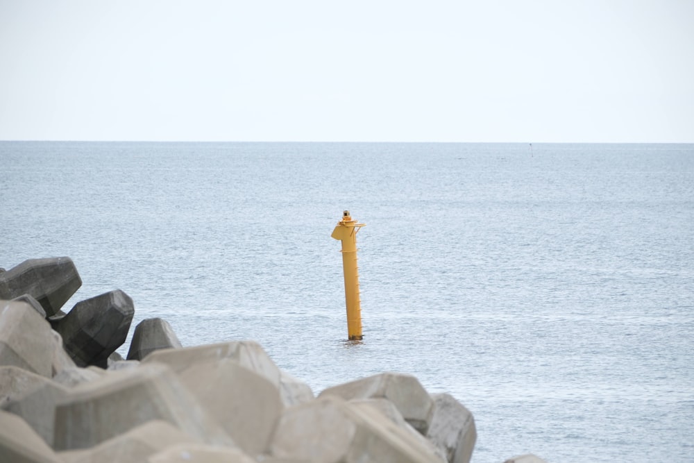 a yellow fire hydrant in the middle of a body of water