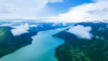 Wide shot of a river winding through mountains captured by drone