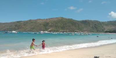 Children from a coastal village smiling and playing near the turquoise waters of the Indian Ocean.