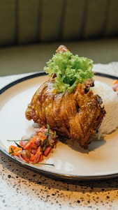 A vibrant plate of golden fried chicken paired with steaming jasmine rice and fresh vegetables.