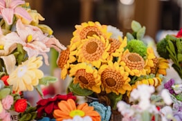 A collection of intricately crocheted flowers, including sunflowers and other varieties, arranged in a vibrant and colorful display.