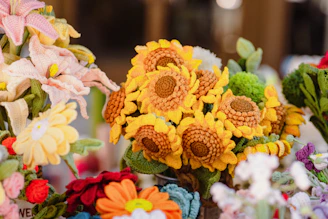 A collection of colorful crochet souvenirs with floral and geometric designs.