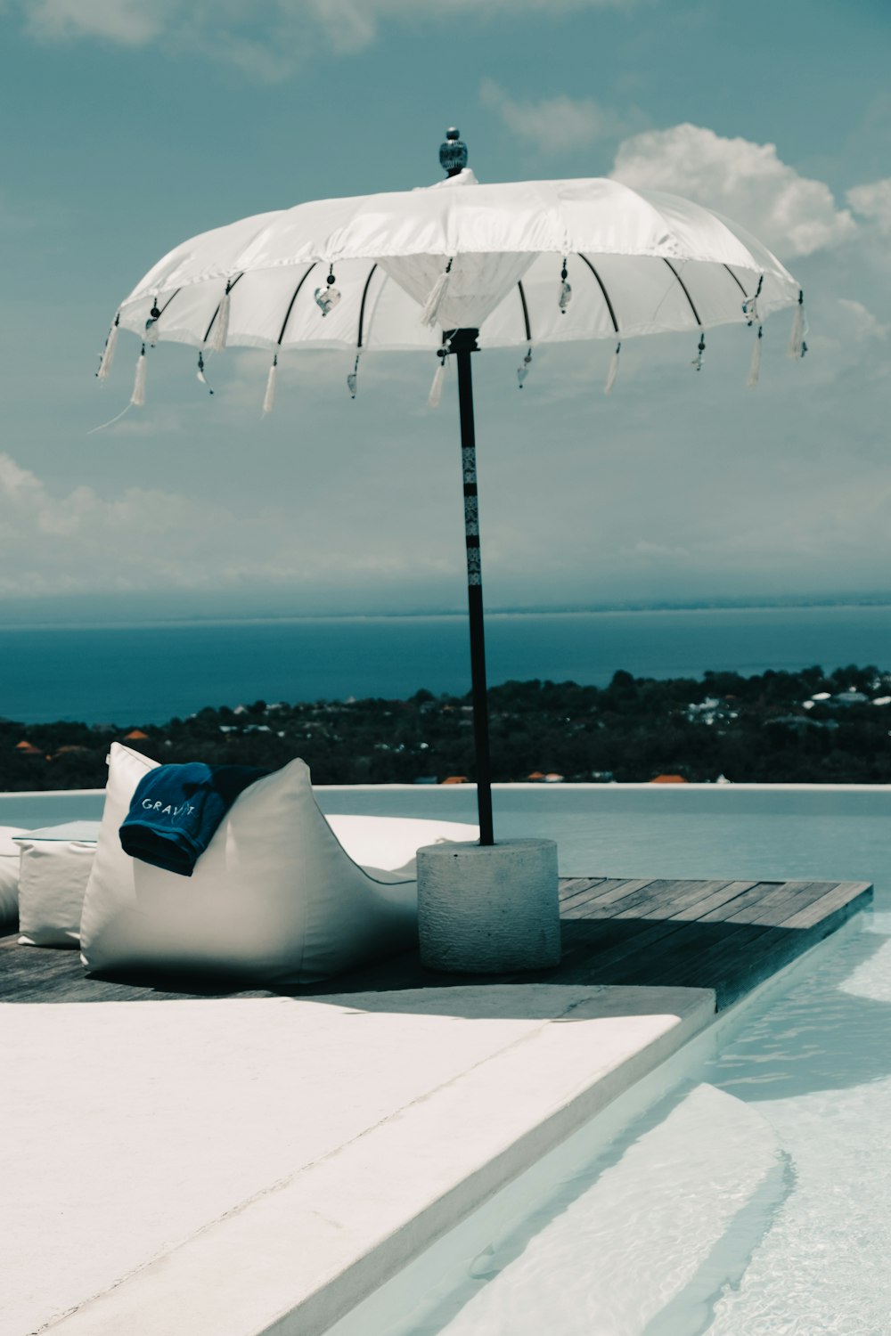 a large white umbrella sitting on top of a pool