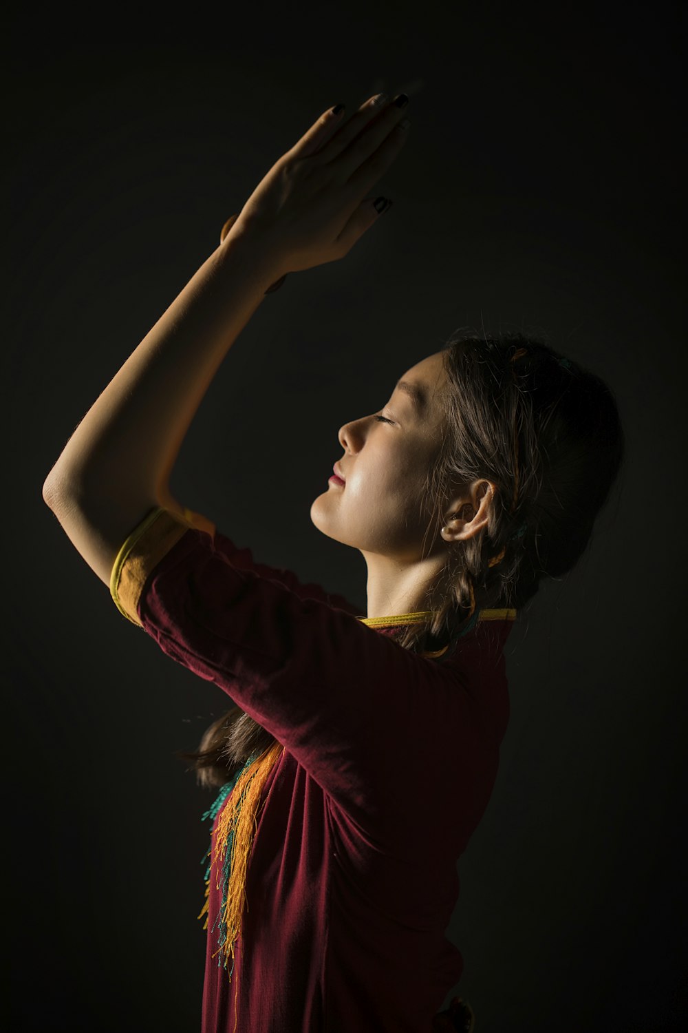 a woman in a red shirt is holding her hands up