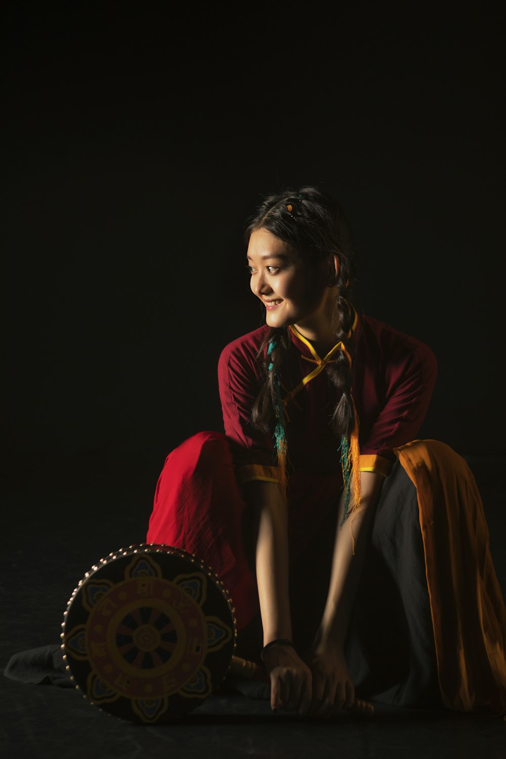 a woman sitting on the ground next to a basket