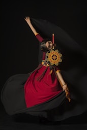 a woman in a red and black dress is dancing