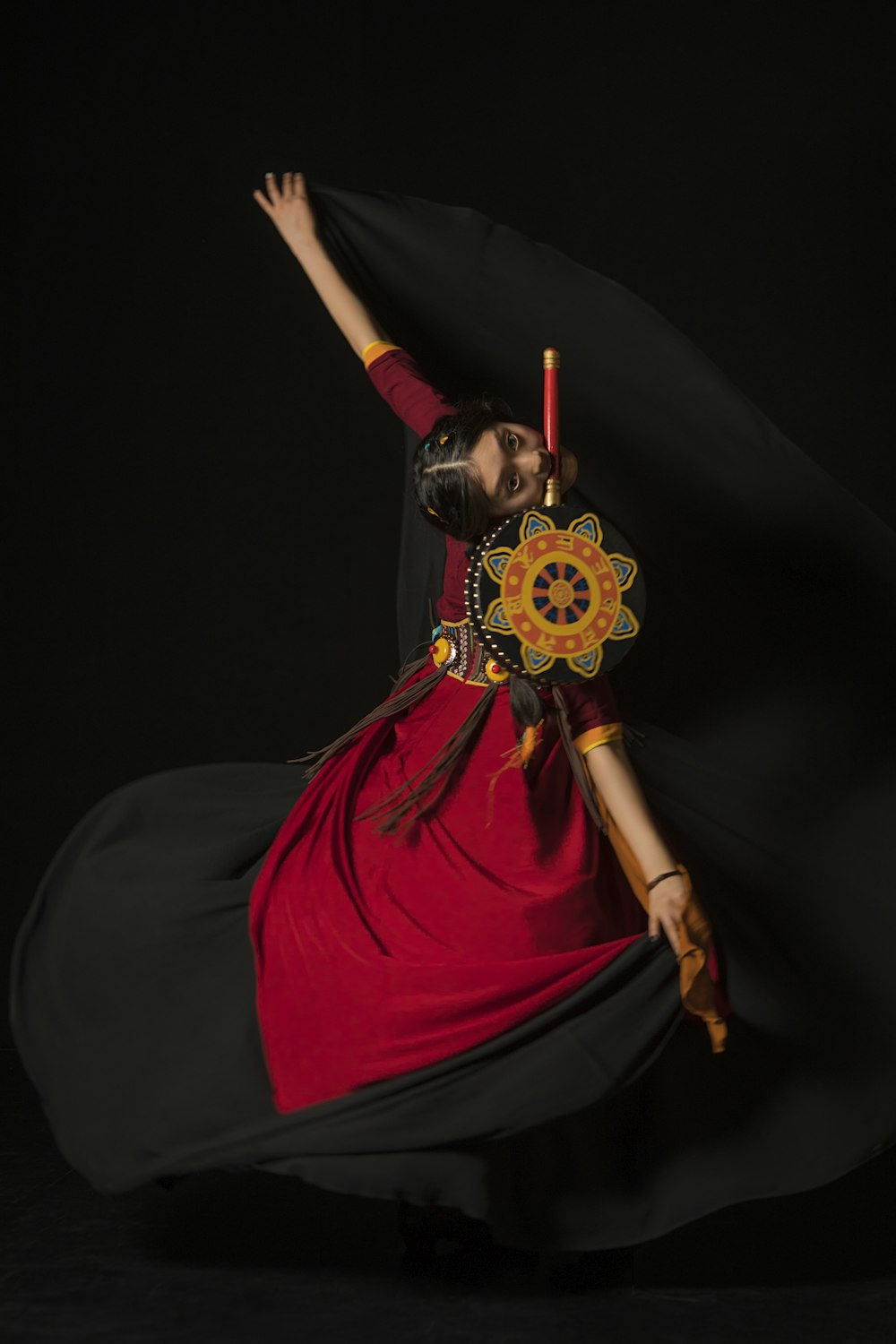 a woman in a red and black dress is dancing