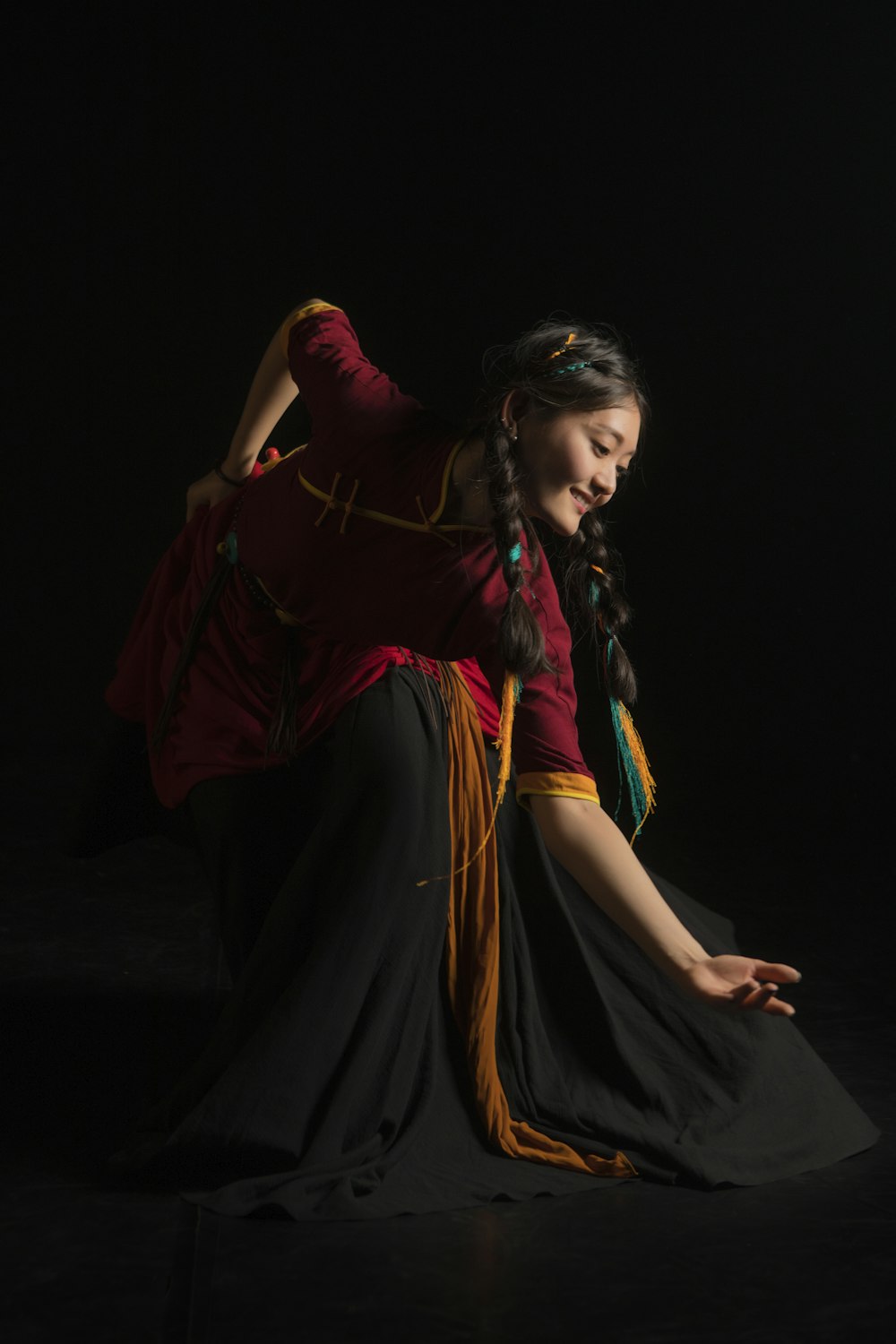 a woman sitting on the ground in a dark room