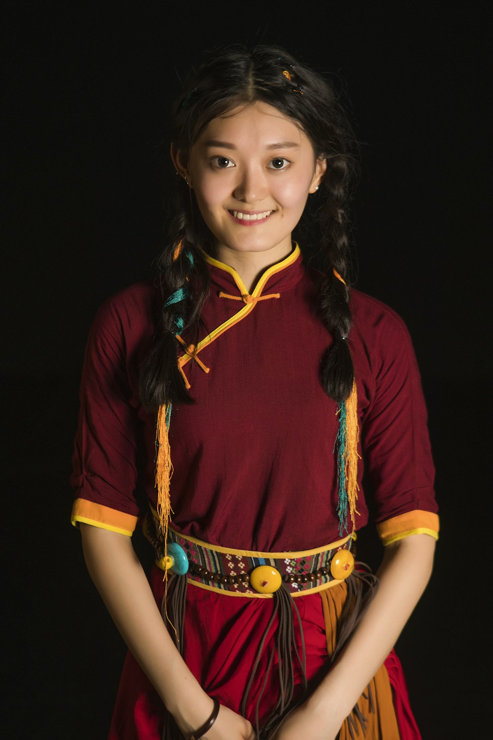 a young girl in a red and yellow dress