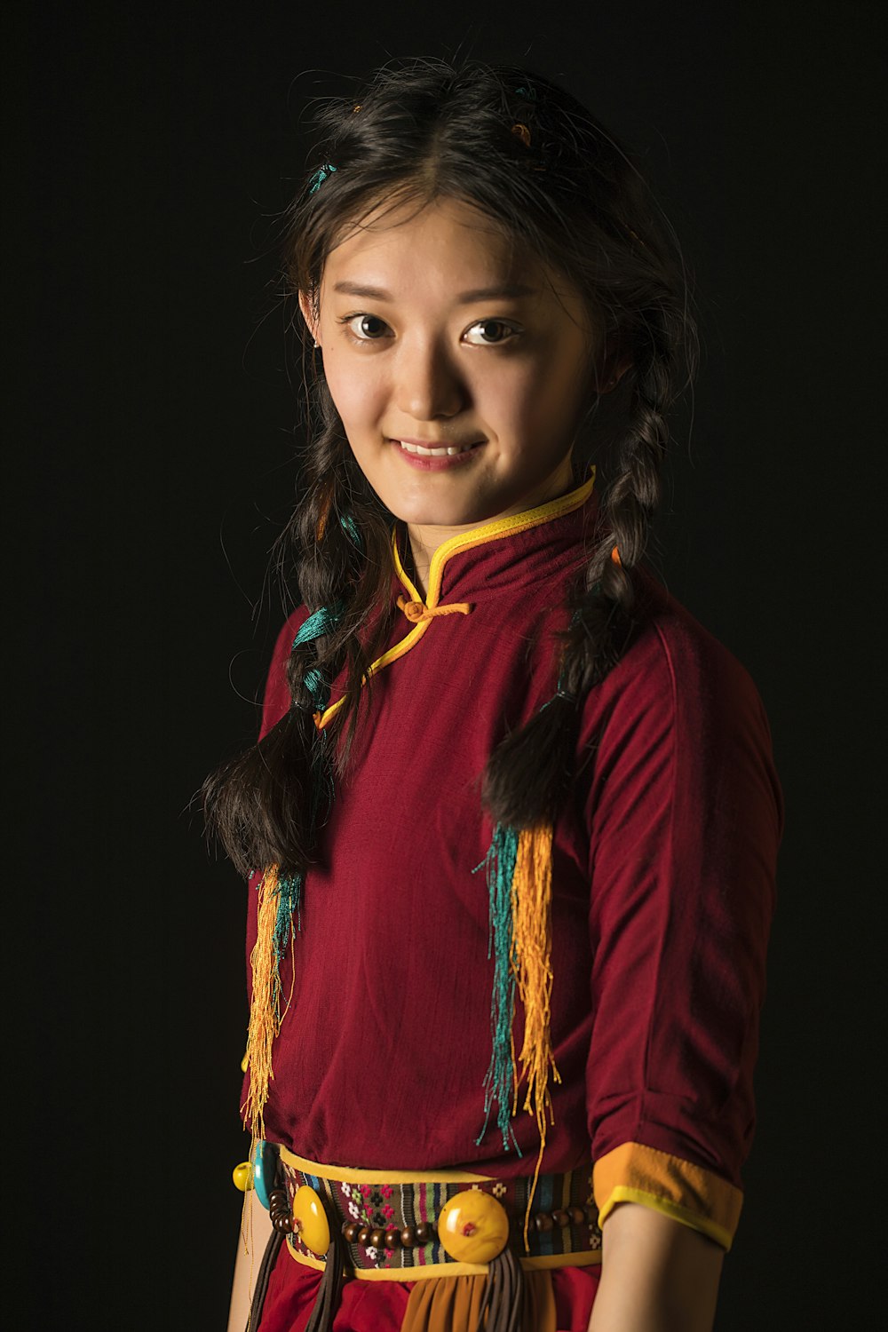 a young girl in a red and yellow dress