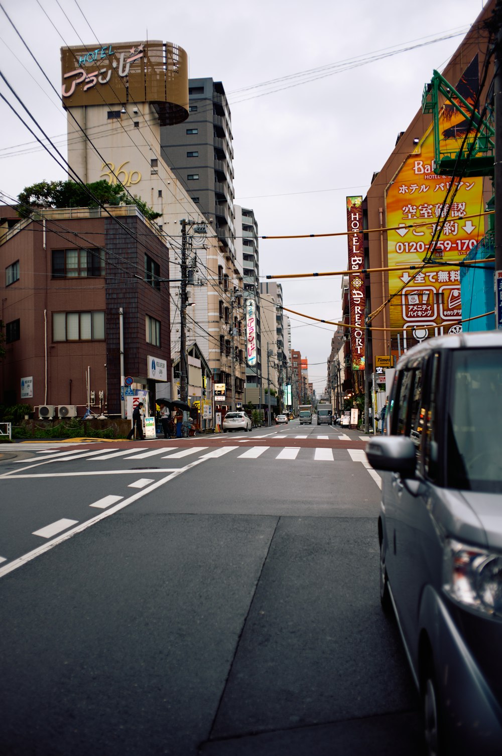 a car driving down a street next to tall buildings