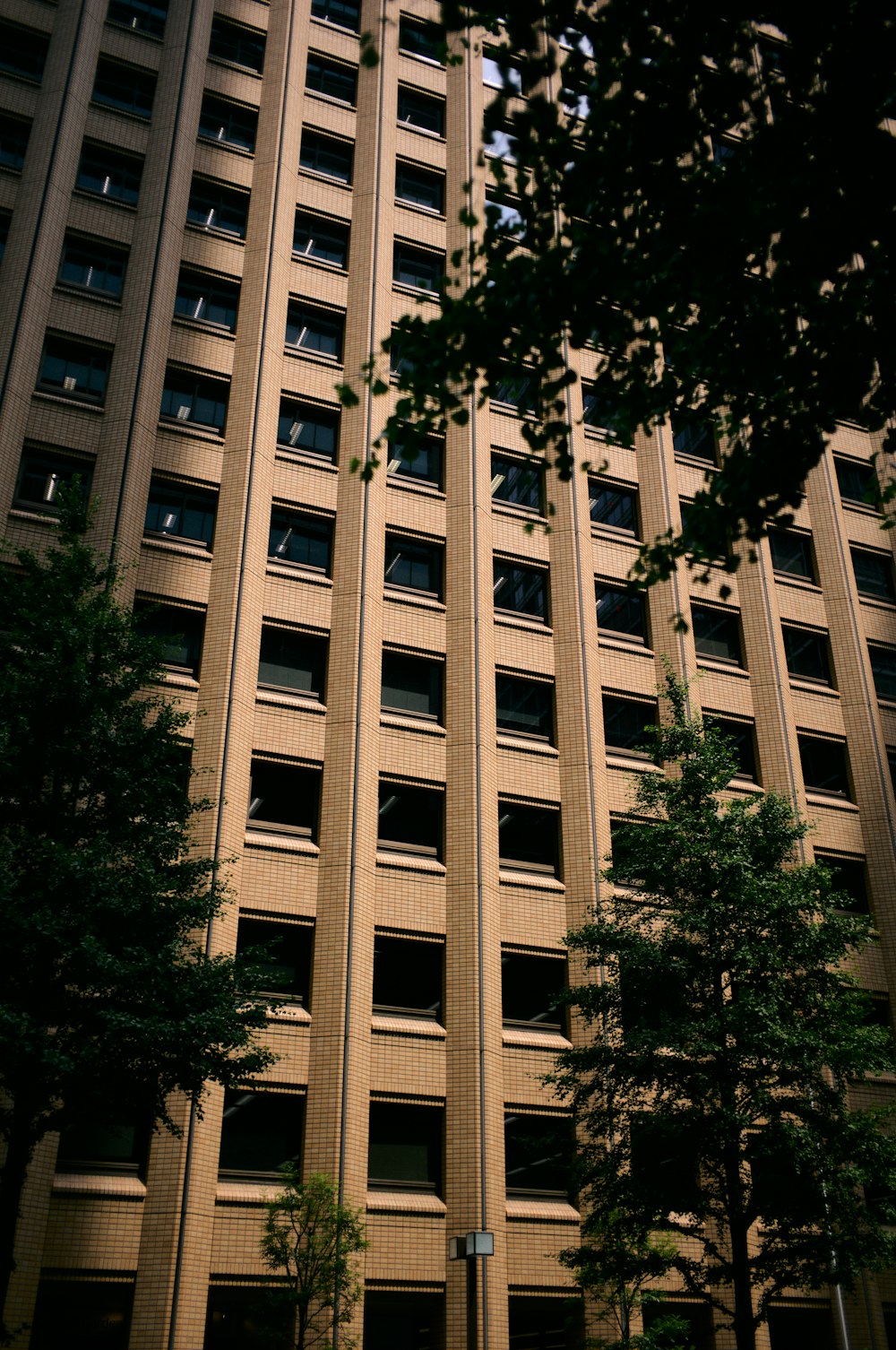 a tall building with lots of windows next to trees