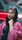 a woman in a hijab and sunglasses standing in front of a red car