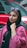 a woman in a hijab and sunglasses standing in front of a red car