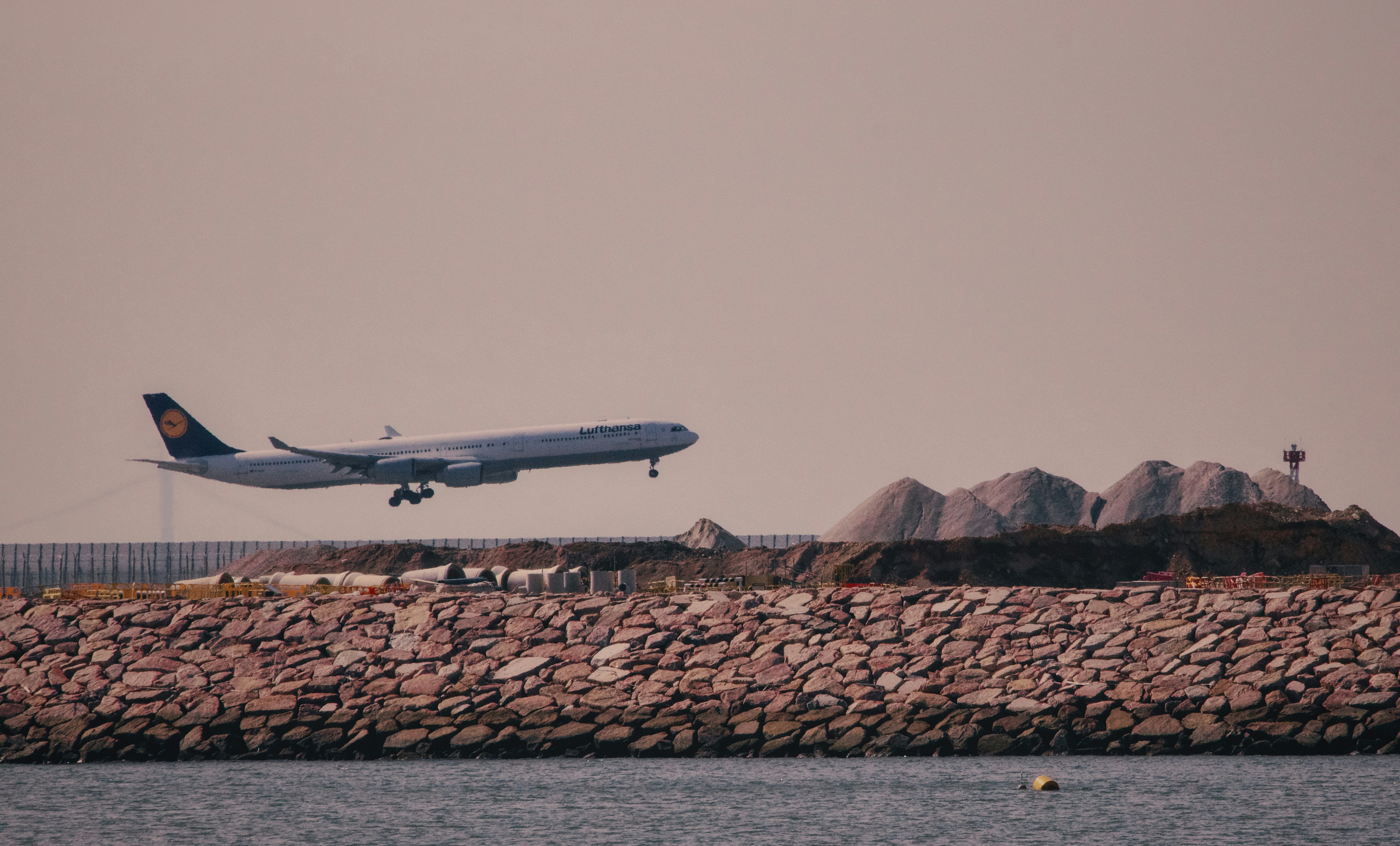 a large jetliner flying over a body of water, 