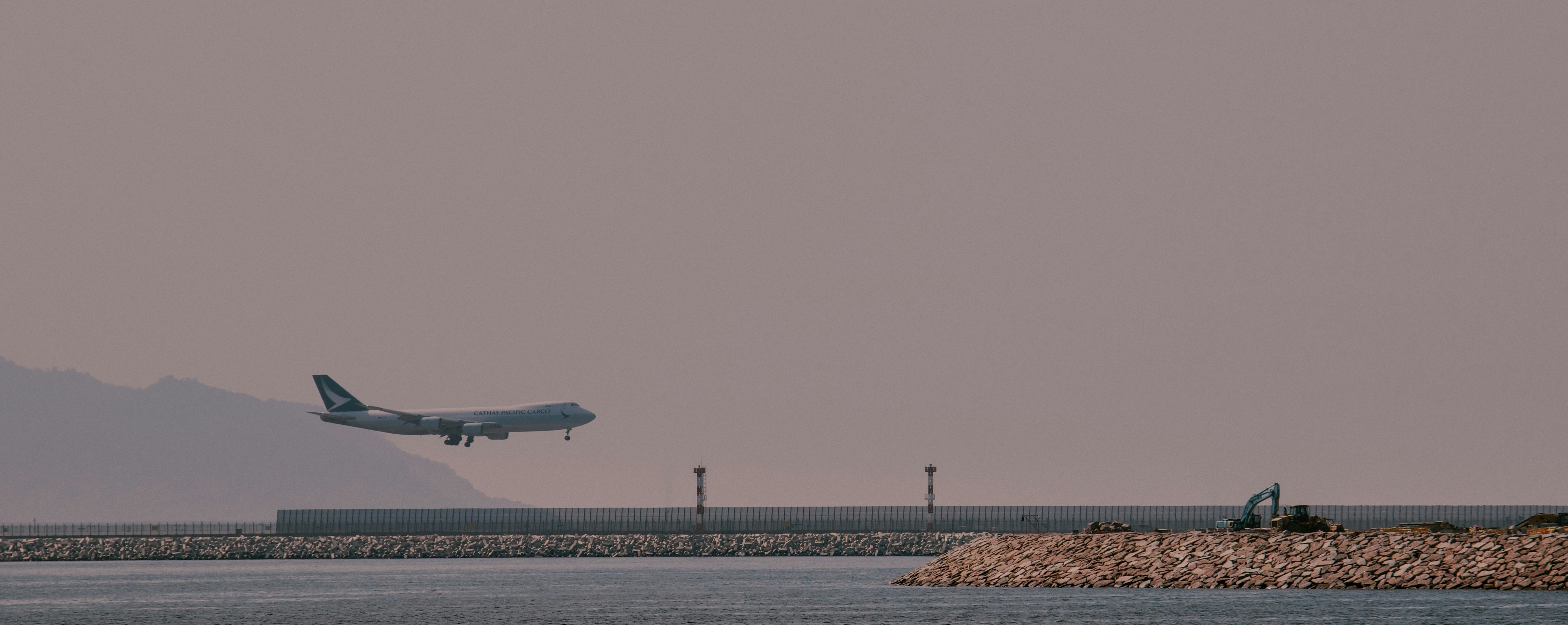 a large jetliner flying over a body of water, 