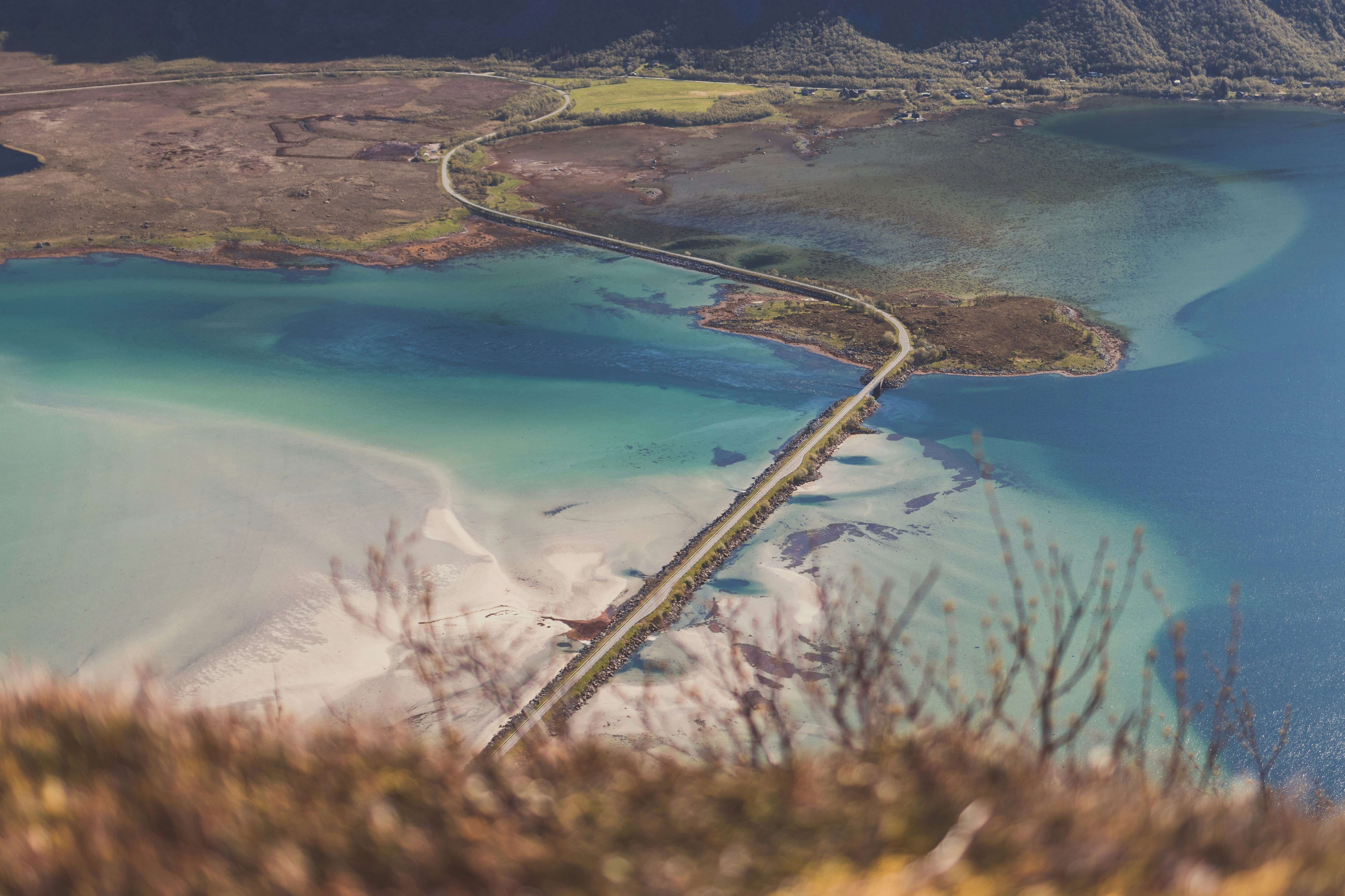 an aerial view of a road and a body of water