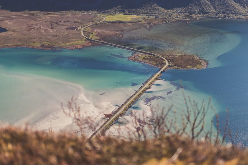 an aerial view of a road and a body of water