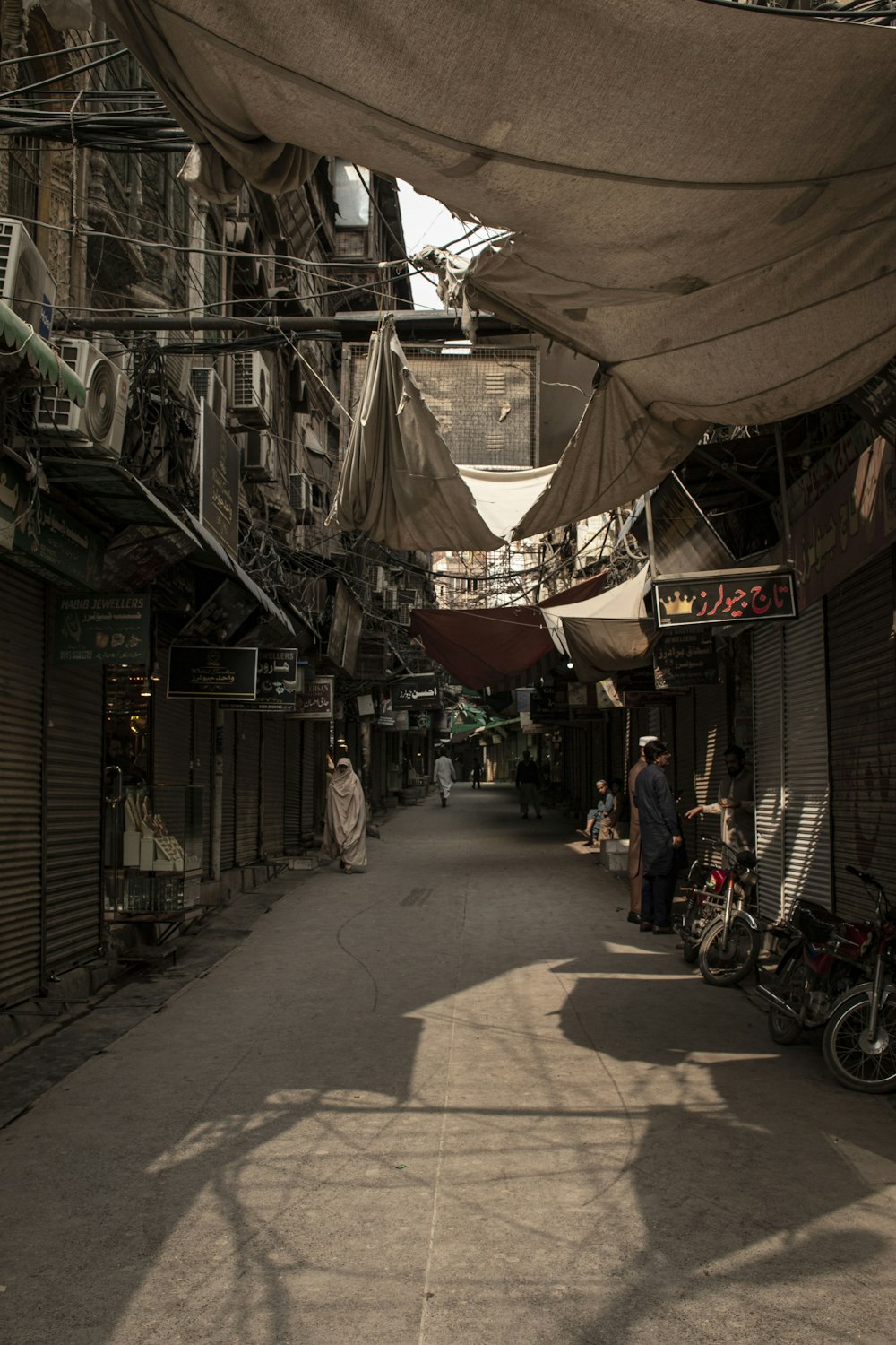 a narrow alley way with a few people walking down it