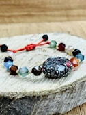 Close-up of a sleek crystal beaded bracelet resting on a wooden surface.