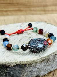 Close-up of a handcrafted macramé bracelet with natural Puerto Rican stones on a wooden surface.