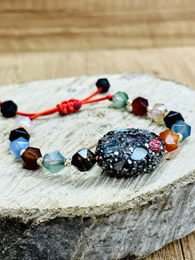 Close-up of a handcrafted macramé bracelet with natural Puerto Rican stones on a wooden surface.
