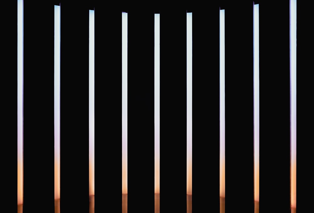 a group of thin thin poles against a black background