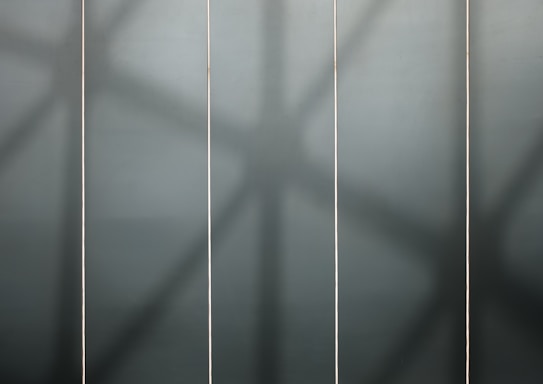 Four vertical panels highlighted by soft shadows, giving a geometric and abstract aesthetic.