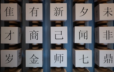 Several large white cubes with black Chinese characters are arranged in vertical columns against a blue background.