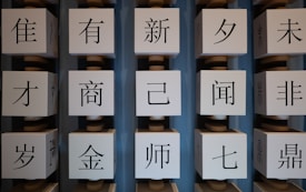 Several large white cubes with black Chinese characters are arranged in vertical columns against a blue background.