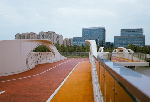 A modern pedestrian bridge made of pultruded PRFV with sleek guardrails, surrounded by greenery.