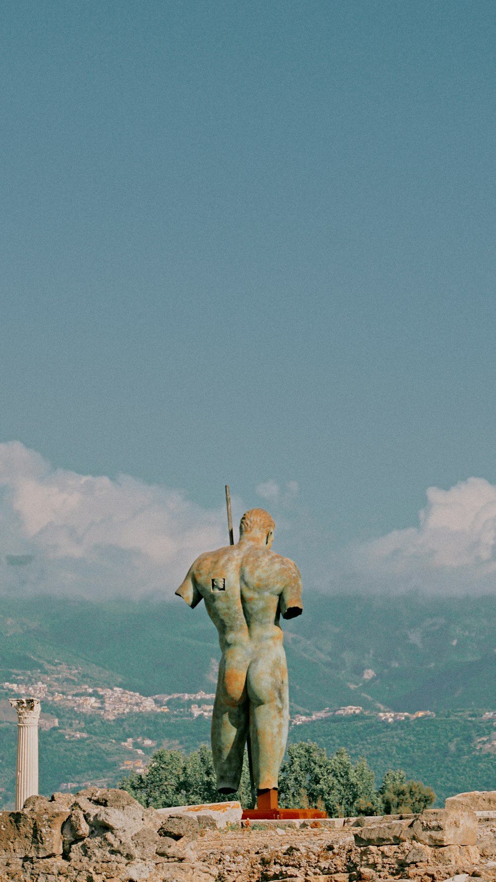 a statue of a man holding a sword on top of a hill