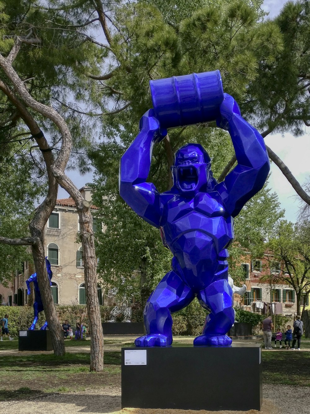 a blue sculpture of a man holding a barrel